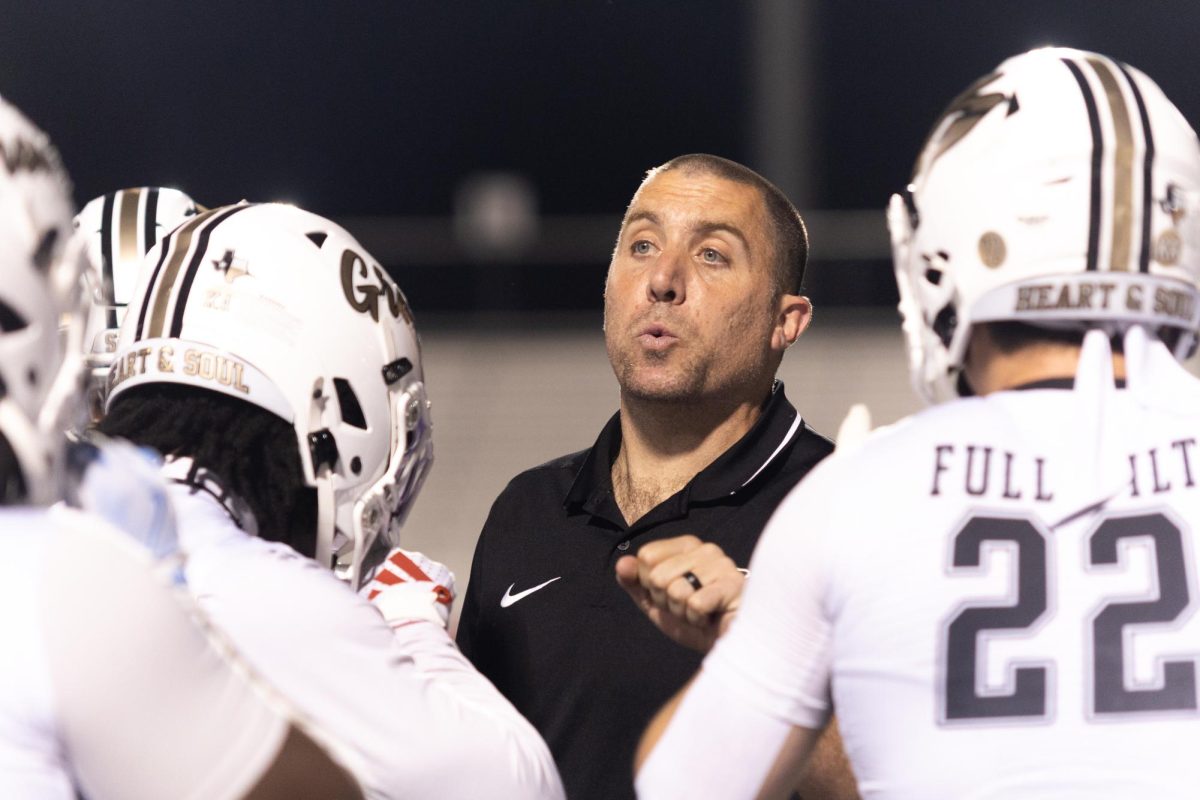 During a football game, defensive coordinator Jonathan Darby talks through one of the plays. 